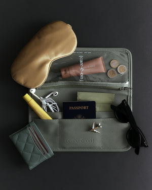 Care.ē.on Carry-All packed with skincare, passport, sleep mask, sunglasses, headphones, and other travel essentials.