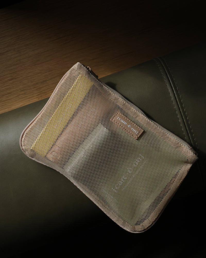 Care.ē.on En Route Essentials Kit mesh pouch filled with travel-size skincare products.