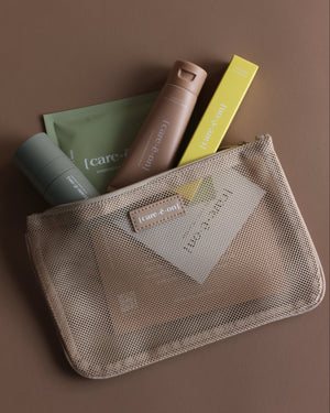 Care.ē.on travel-size skincare essentials packed inside the En Route Essentials Kit mesh bag.