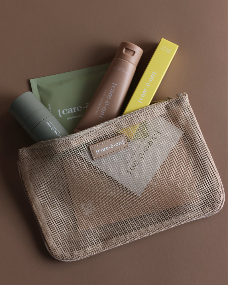 Care.ē.on travel-size skincare essentials packed inside the En Route Essentials Kit mesh bag.