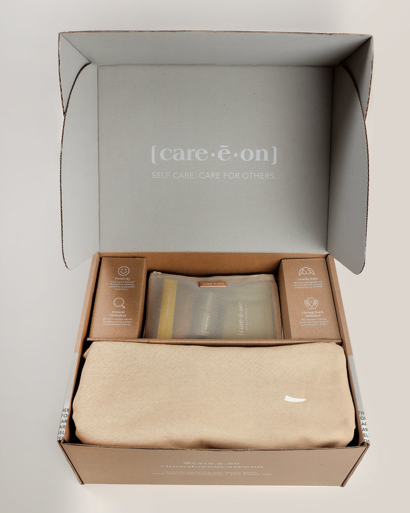 Open Care.ē.on PR/VIP Box featuring the En Route Essentials Kit, En Route Hoodie, and Vegan Voyage Luggage Tag.