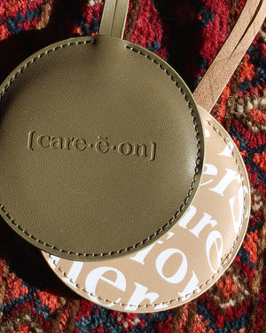 Green and tan Care.ē.on Vegan Voyage Luggage Tags laid together.